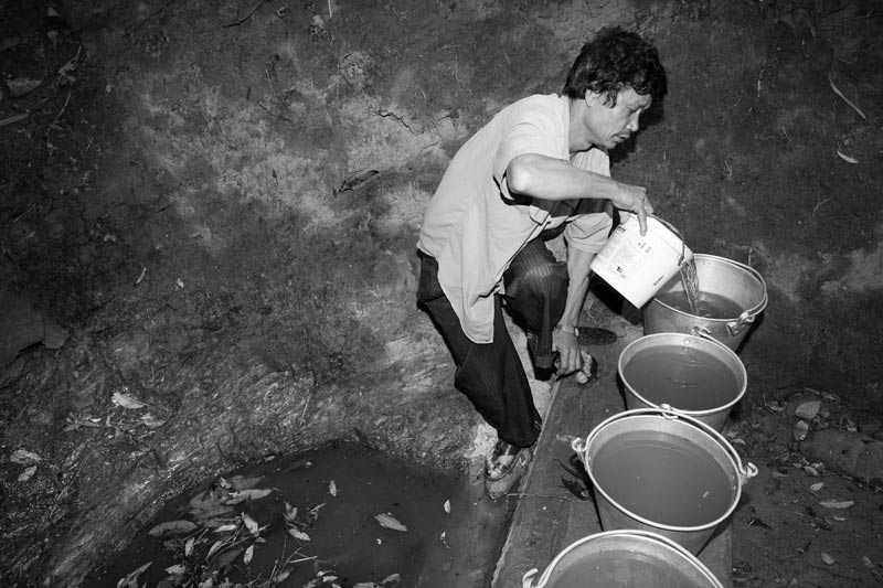 Collecting drinking water from an unprotected spring in Zunheboto district, Nagaland